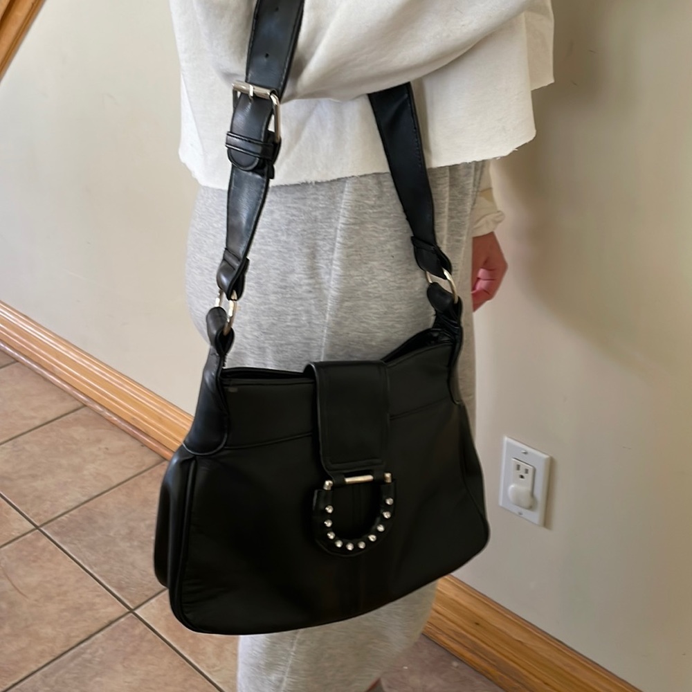 Black leather bag/purse with detail flap closure and zippered inside pocket.